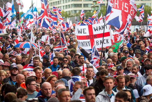 Aerial view of massive crowd gathered outside Downing Street gates with protest banners